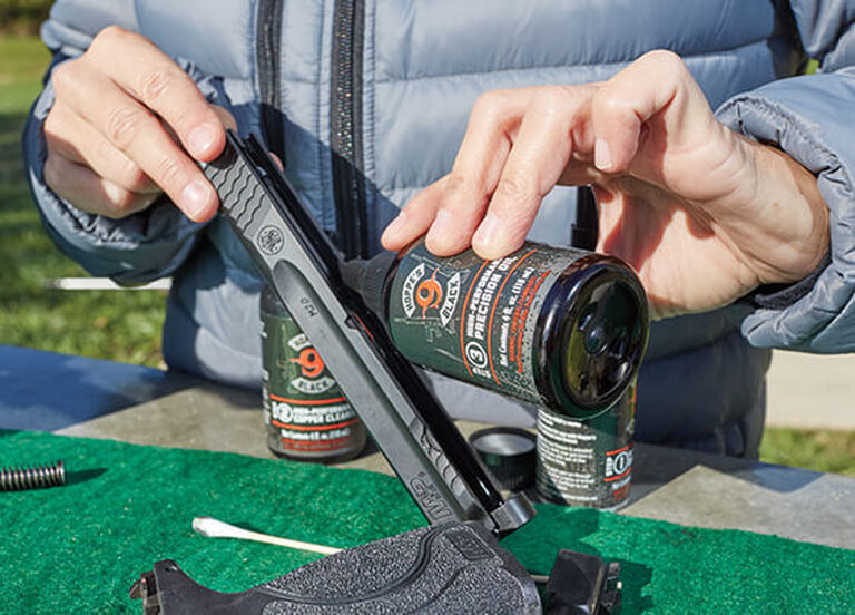 Shooter cleaning pistol with Hoppe's Black High-Performance Precision Oil